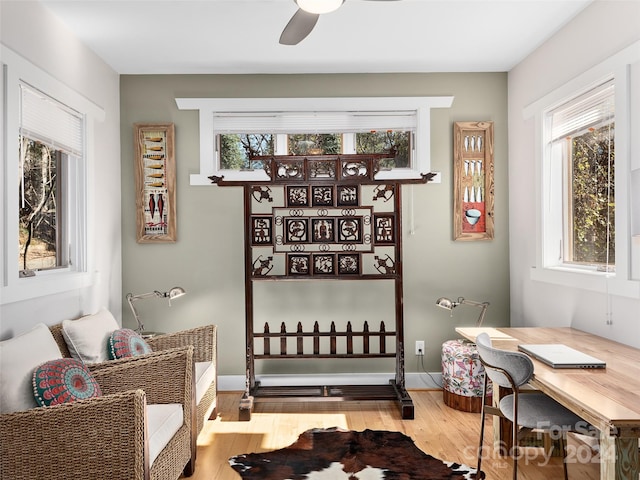 living area with hardwood / wood-style floors and ceiling fan