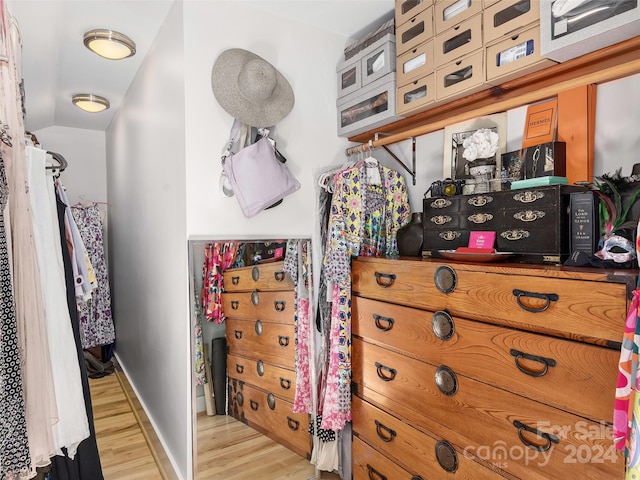 walk in closet with light hardwood / wood-style floors