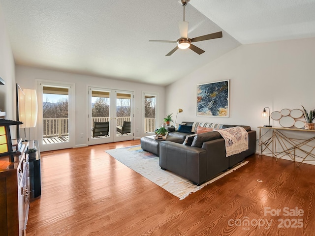 living room featuring hardwood / wood-style flooring, ceiling fan, a textured ceiling, and vaulted ceiling