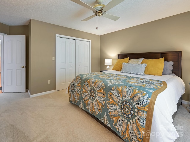 carpeted bedroom with a textured ceiling, a closet, and ceiling fan