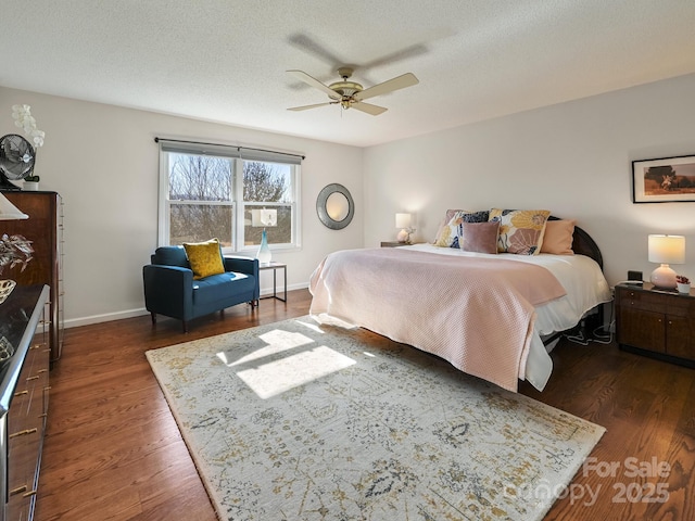 bedroom with ceiling fan, dark hardwood / wood-style flooring, and a textured ceiling