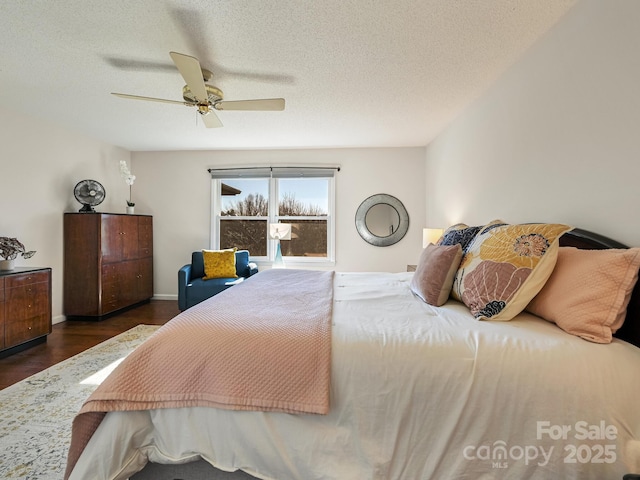 bedroom with a textured ceiling, dark hardwood / wood-style flooring, and ceiling fan