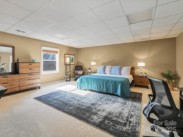 carpeted bedroom with a drop ceiling