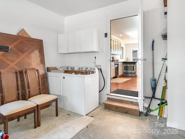 laundry area featuring washer and dryer, cabinets, and a textured ceiling