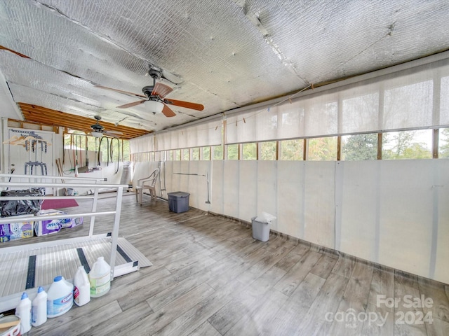 unfurnished sunroom featuring ceiling fan