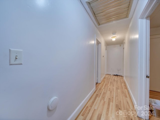 hallway featuring light hardwood / wood-style floors and crown molding