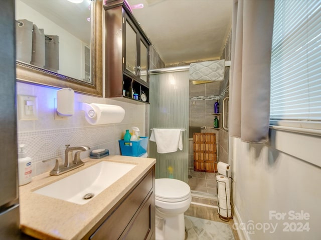 bathroom with walk in shower, vanity, toilet, and tile walls