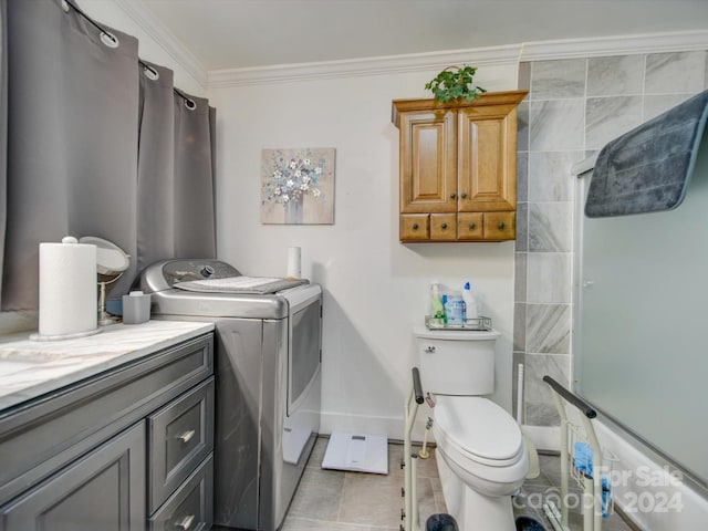 bathroom with tile patterned floors, an enclosed shower, ornamental molding, washing machine and clothes dryer, and toilet