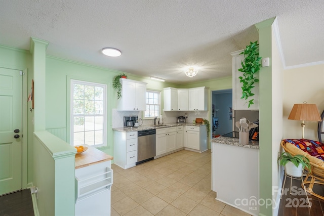 kitchen with white cabinets, ornamental molding, sink, and dishwasher