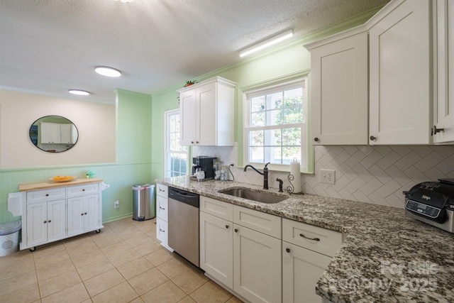 kitchen featuring sink, dishwasher, white cabinetry, light stone countertops, and a textured ceiling