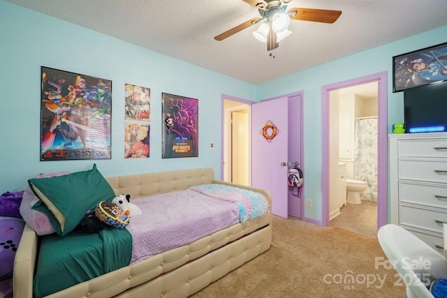 bedroom featuring ensuite bathroom, light colored carpet, ceiling fan, and a textured ceiling