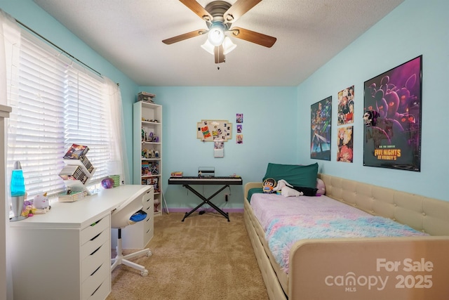 bedroom with ceiling fan, light colored carpet, and a textured ceiling