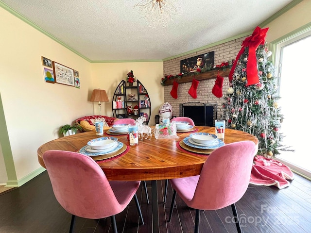 dining area featuring crown molding, hardwood / wood-style flooring, a fireplace, and a textured ceiling