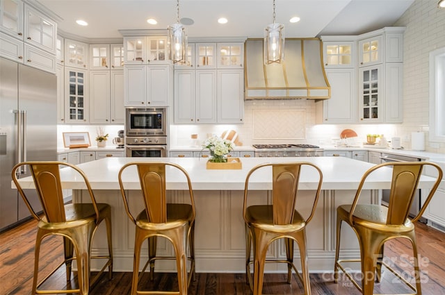 kitchen with built in appliances, custom exhaust hood, and a center island