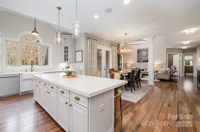 kitchen with a breakfast bar area, white cabinetry, a kitchen island, and stainless steel dishwasher