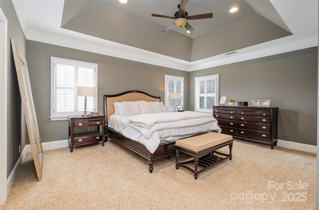 carpeted bedroom featuring a tray ceiling, ceiling fan, and crown molding