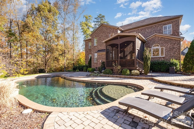 view of pool featuring a patio and a sunroom