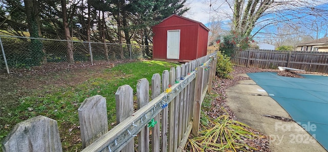 view of yard with a covered pool and a storage shed