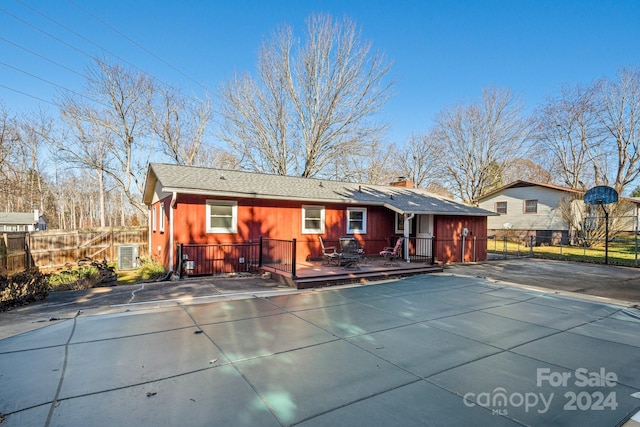 back of property with a covered pool and a patio area