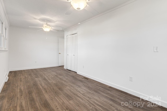 spare room featuring a textured ceiling, dark hardwood / wood-style floors, ceiling fan, and crown molding