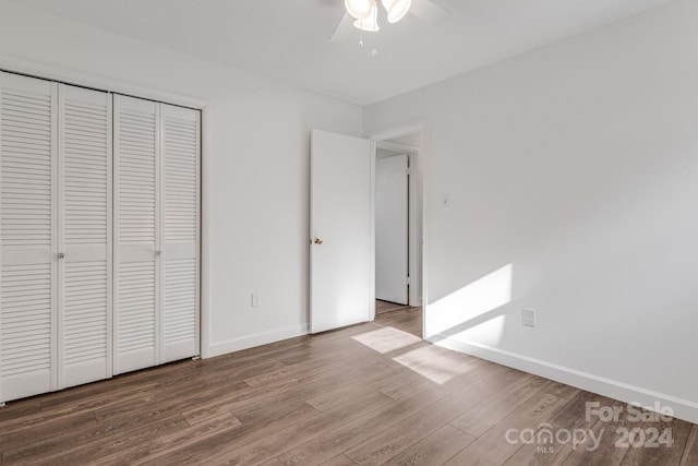 unfurnished bedroom with ceiling fan, a closet, and wood-type flooring