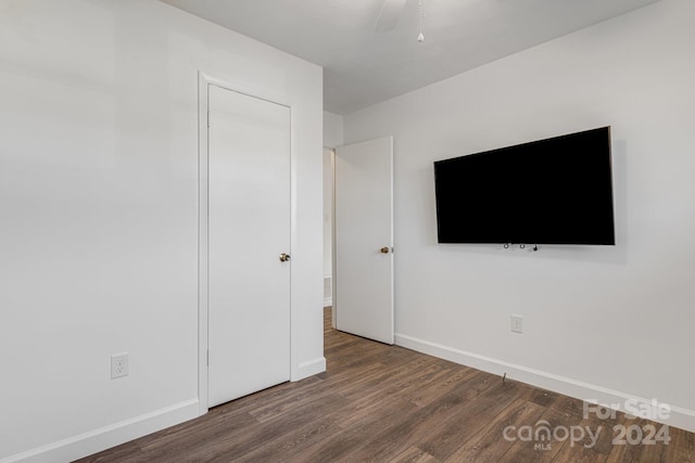 unfurnished bedroom featuring ceiling fan and dark hardwood / wood-style floors