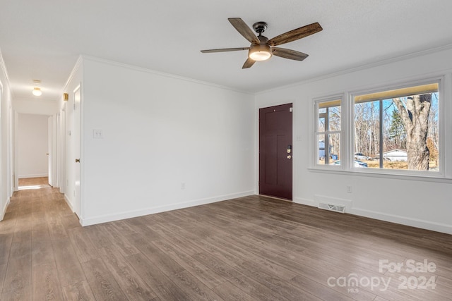 empty room with ceiling fan, ornamental molding, and hardwood / wood-style flooring