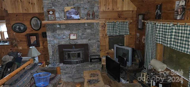 living room with a wood stove, wooden walls, and hardwood / wood-style flooring