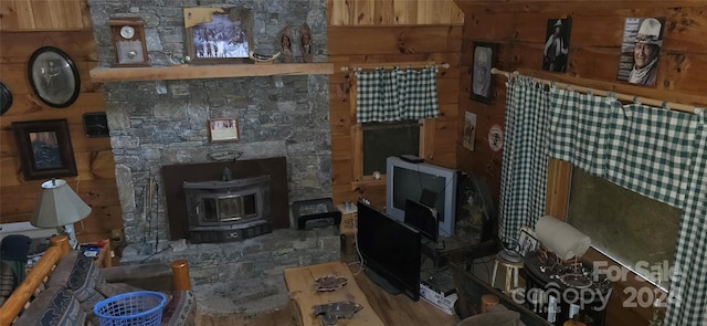 living room with a wood stove and wood walls