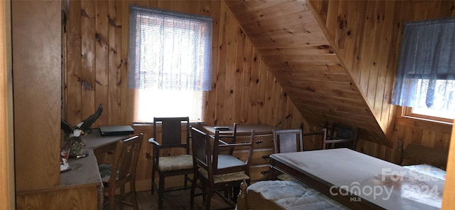 interior space with a wealth of natural light, wood walls, and lofted ceiling