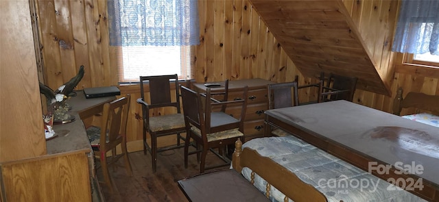 bedroom featuring wooden walls and dark hardwood / wood-style floors