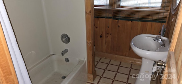 bathroom with wooden walls and tub / shower combination