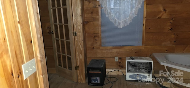 bathroom featuring heating unit and wood walls