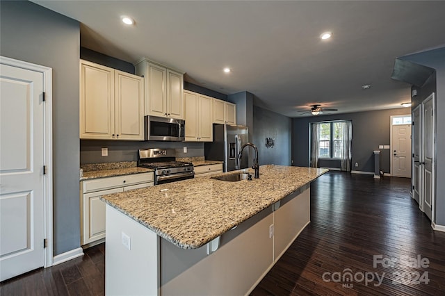 kitchen with dark hardwood / wood-style flooring, sink, stainless steel appliances, and an island with sink