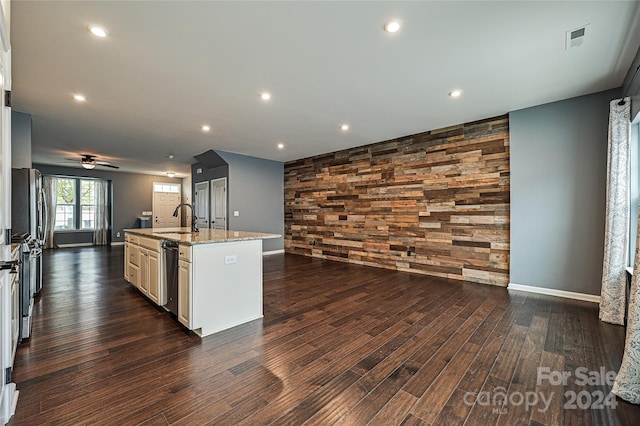 kitchen featuring light stone counters, dark hardwood / wood-style floors, sink, and a kitchen island with sink