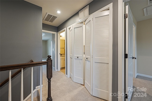 corridor featuring light colored carpet