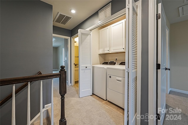 laundry area with light colored carpet, cabinets, and independent washer and dryer