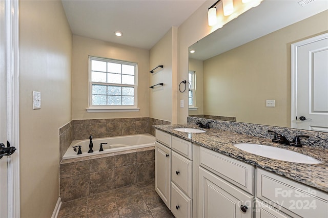 bathroom with vanity and a relaxing tiled tub