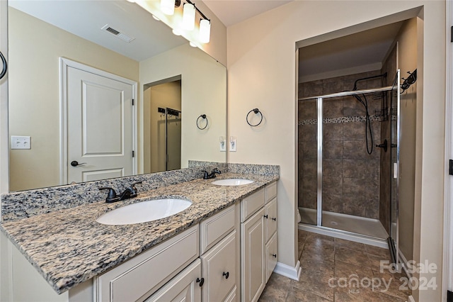 bathroom featuring a shower with door and vanity