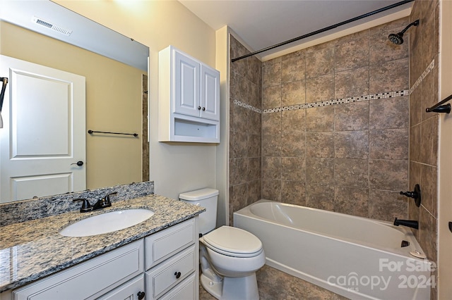 full bathroom with vanity, tiled shower / bath combo, and toilet