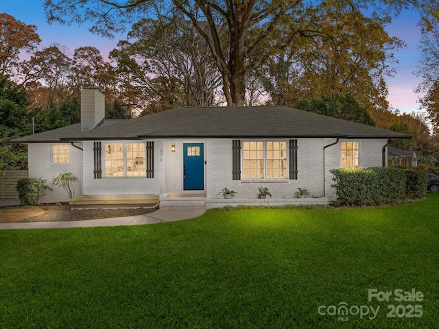 ranch-style home with a lawn