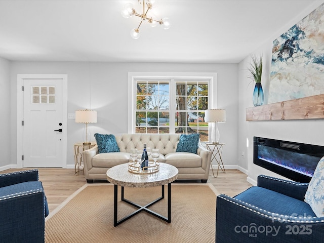 living room featuring light wood-type flooring and a chandelier