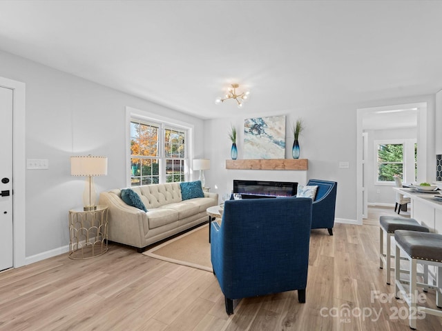 living room with an inviting chandelier and light wood-type flooring