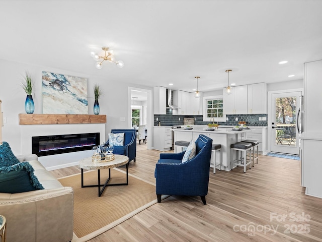 living room with light hardwood / wood-style floors and an inviting chandelier