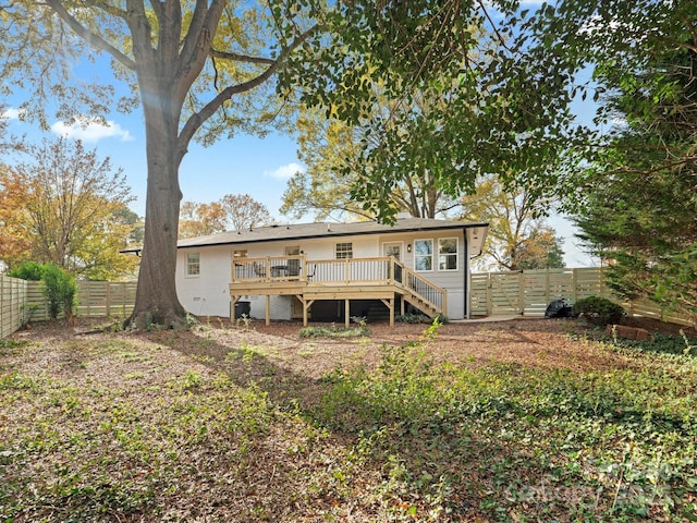 rear view of house featuring a wooden deck