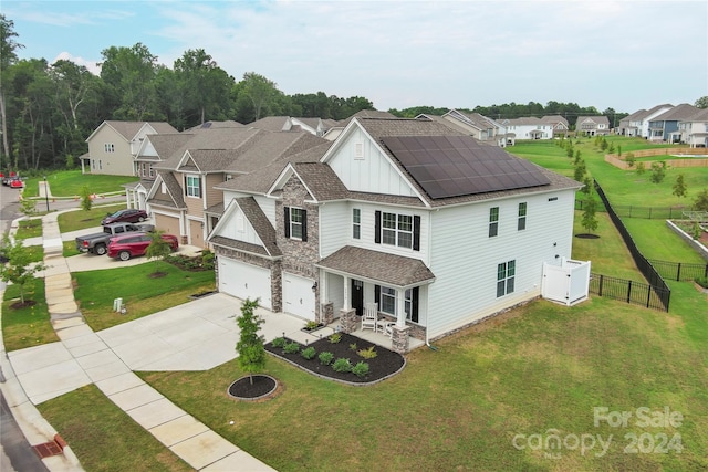 view of front of house with solar panels, a garage, and a front lawn