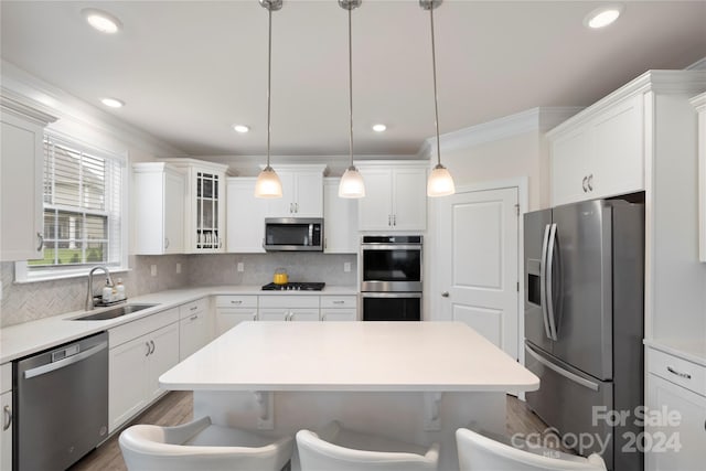 kitchen with decorative backsplash, white cabinets, pendant lighting, and appliances with stainless steel finishes