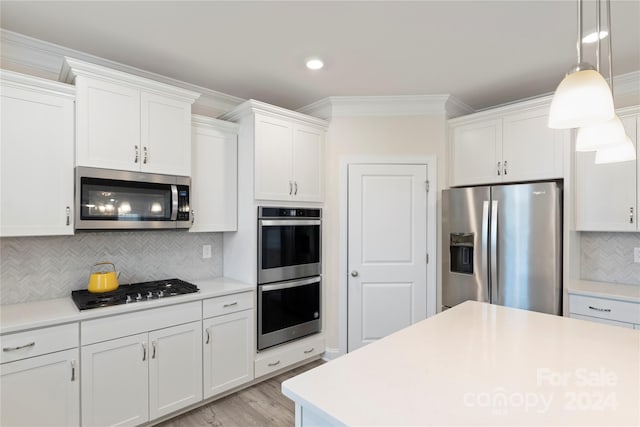 kitchen featuring white cabinets, light wood-type flooring, ornamental molding, appliances with stainless steel finishes, and tasteful backsplash