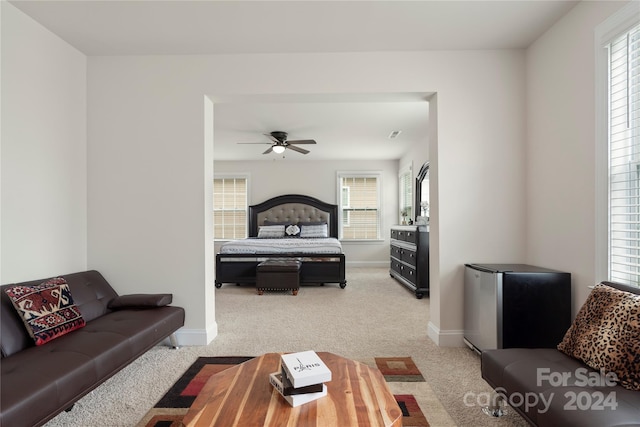 carpeted bedroom with ceiling fan and stainless steel refrigerator