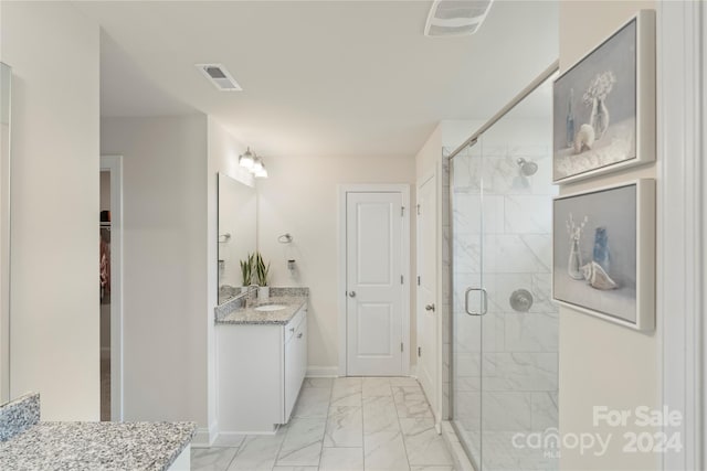 bathroom featuring vanity and a shower with shower door